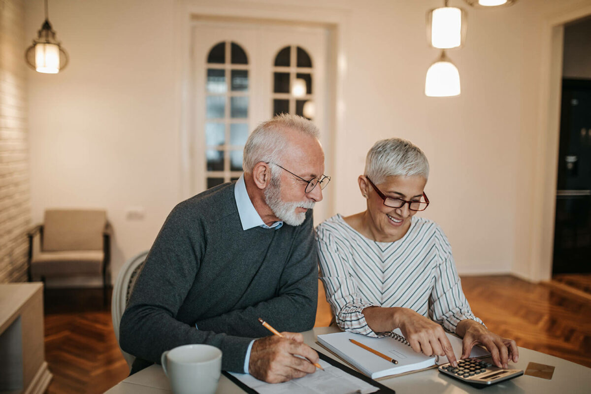 Older couple discussing paperwork at a table.