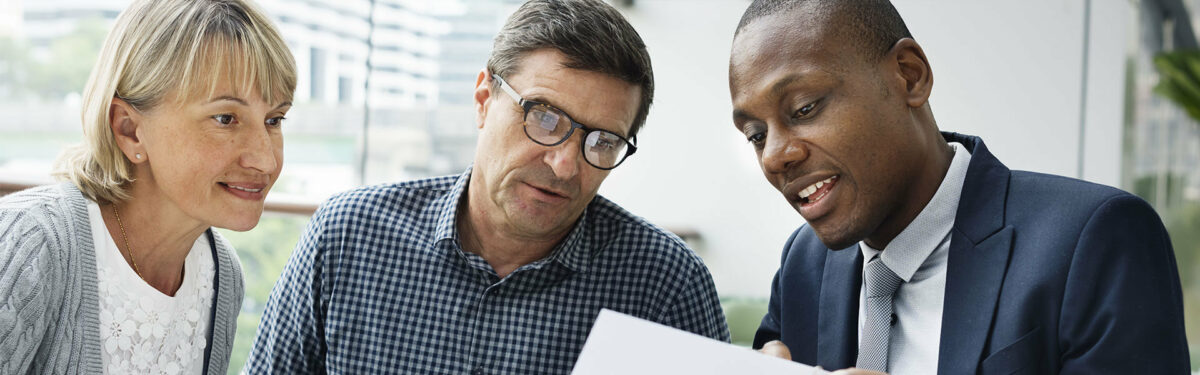 A couple discussing documents with business professional.